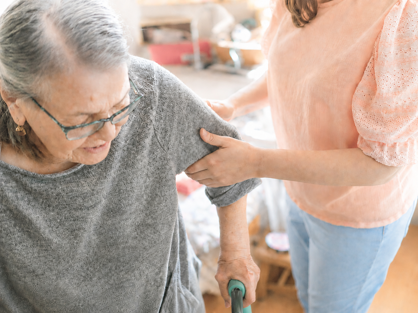 A carer supporting an older adult with safe movement and personal care at home